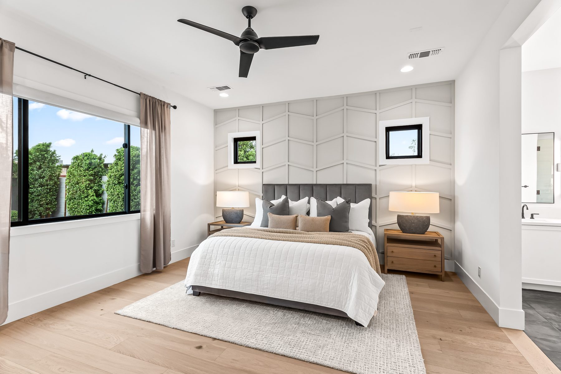 Primary bedroom on the main level with paneled accent wall and natural light, Arcadia, Phoenix