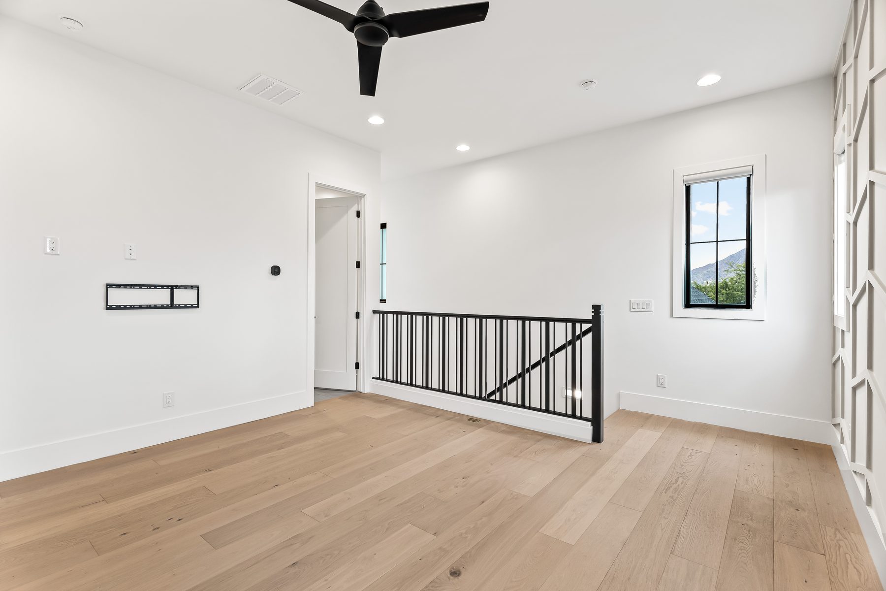 Upstairs loft with black iron stair railing and wood flooring in Lower Arcadia